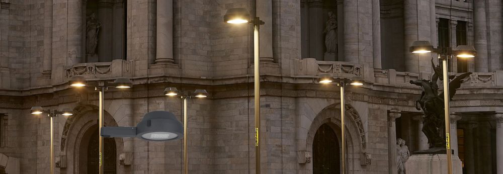 Pole-top luminaires lighting a city plaza at dusk